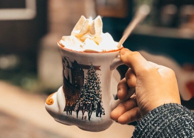 hot chocolate in a mug shaped like a boot, topped with whipped cream
